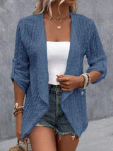 a woman wearing a blue cardigan sweater and denim shorts