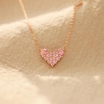 a pink heart shaped necklace on a gold chain