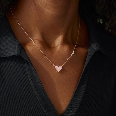 a woman wearing a necklace with a heart on it