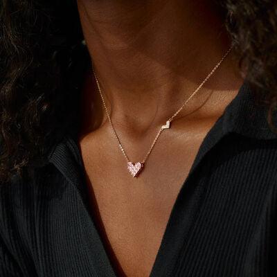 a woman wearing a necklace with a heart on it