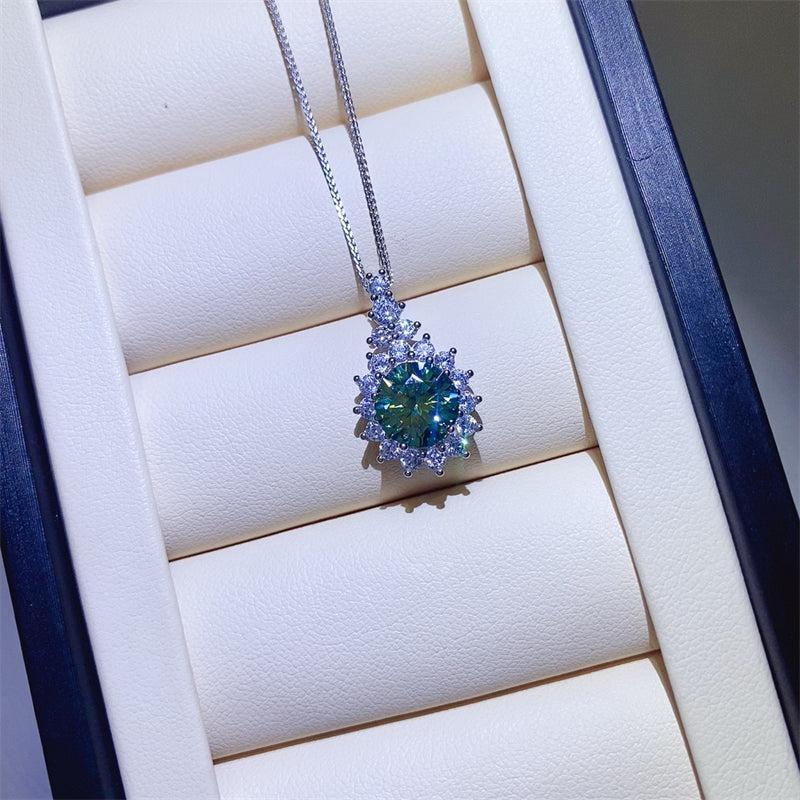 a necklace with a green stone surrounded by diamonds