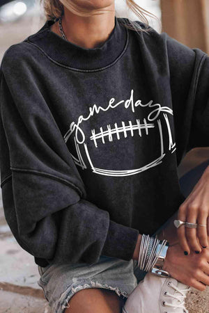 a woman wearing a black sweatshirt with a football on it