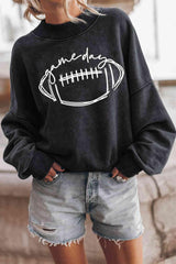 a woman wearing a black sweatshirt with a football on it