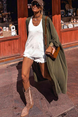 a woman walking down a street wearing boots and a hat