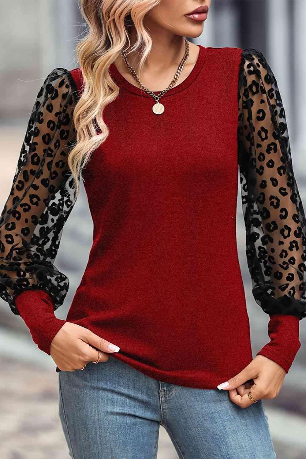 a woman wearing a red top with leopard print sleeves