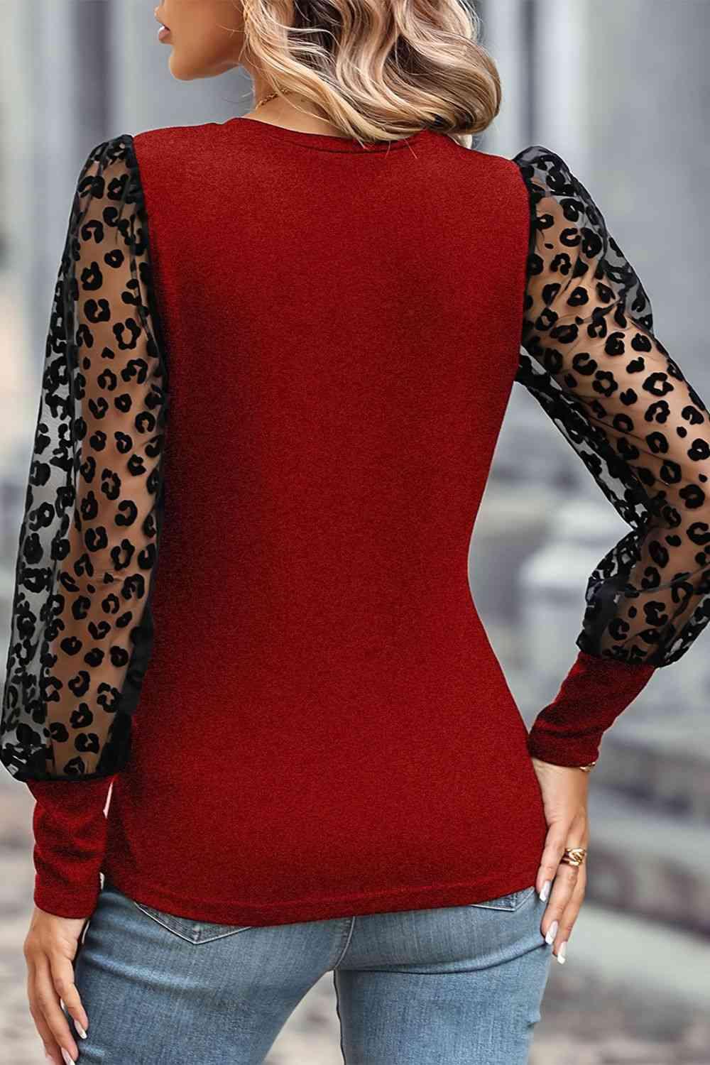 a woman wearing a red top with leopard print sleeves