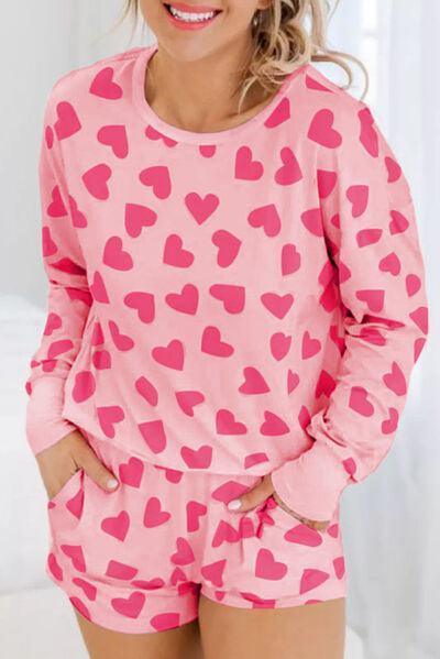 a woman wearing a pink and red heart pajama set