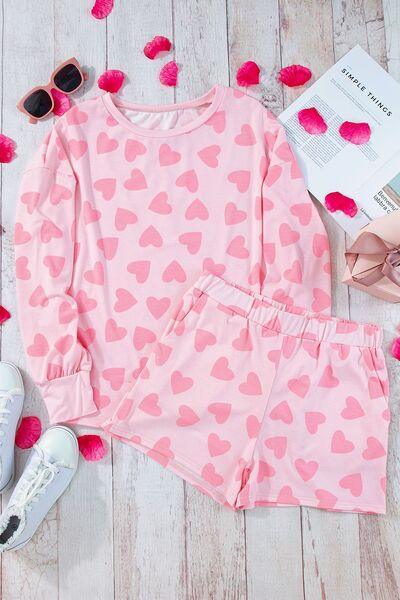 a pink outfit with hearts on it next to a pair of sneakers