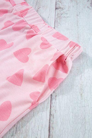 a close up of a pink heart print pants