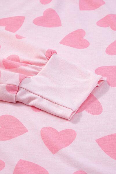 a pink and white bed spread with hearts on it