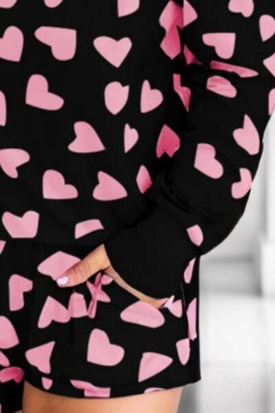 a woman in a pink and black heart print dress