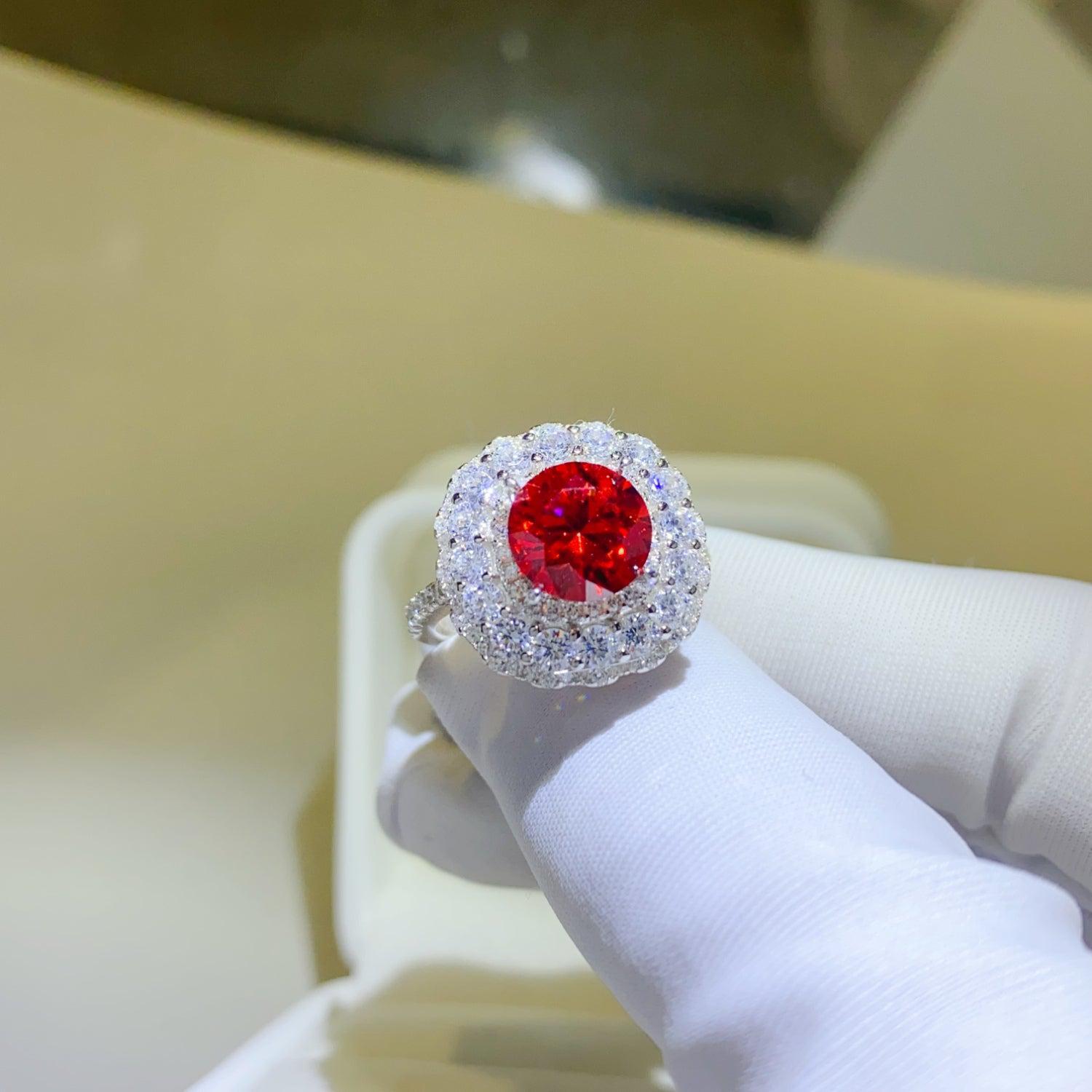 a person wearing a ring with a red stone in it