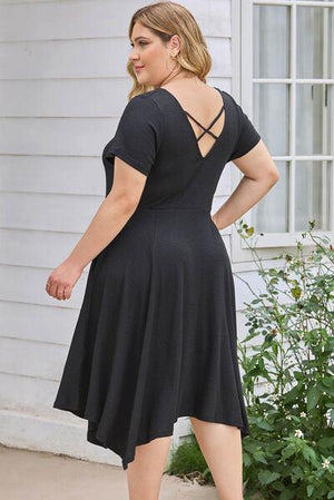 a woman in a black dress is standing outside