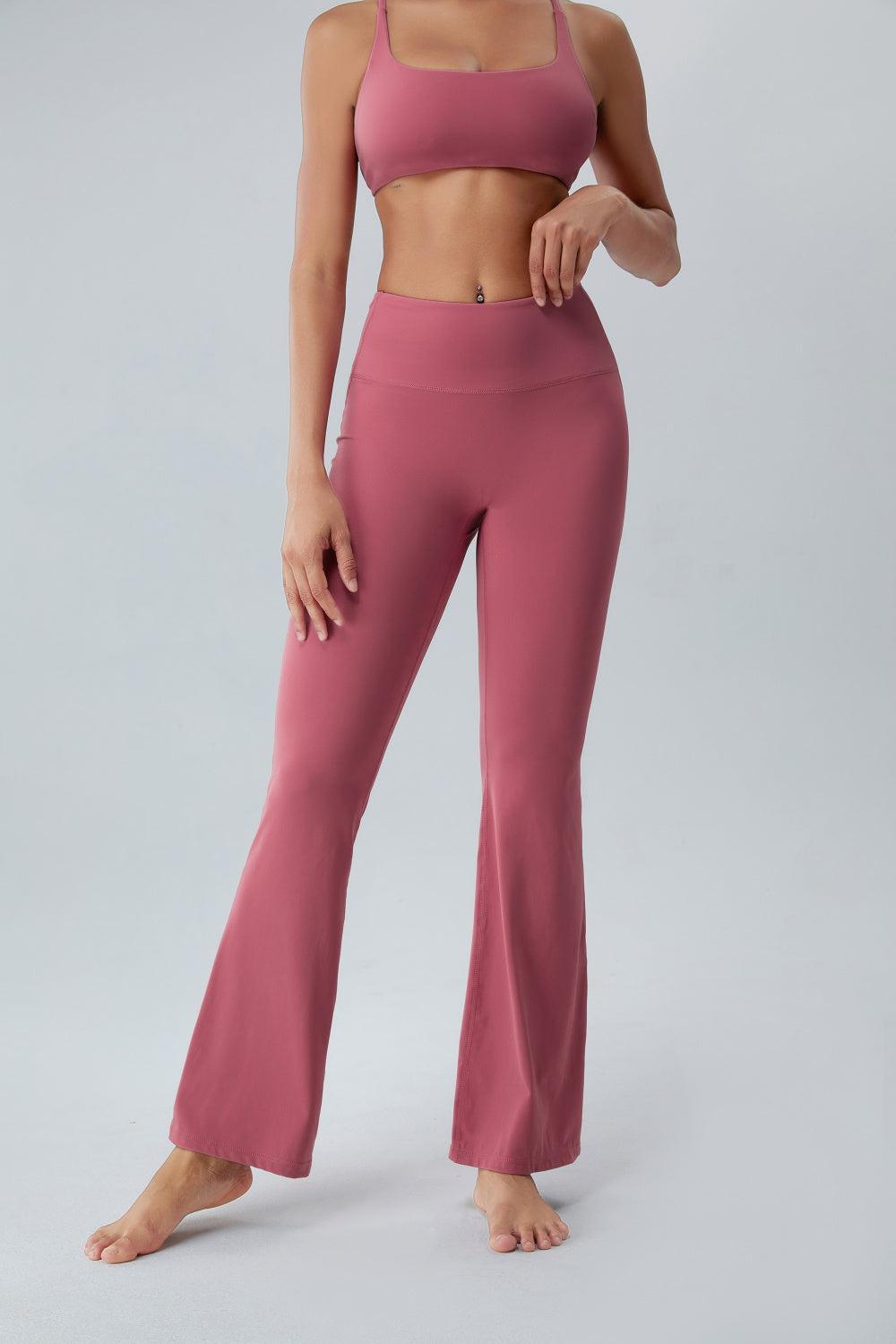 a woman in a pink sports bra top and wide legged pants