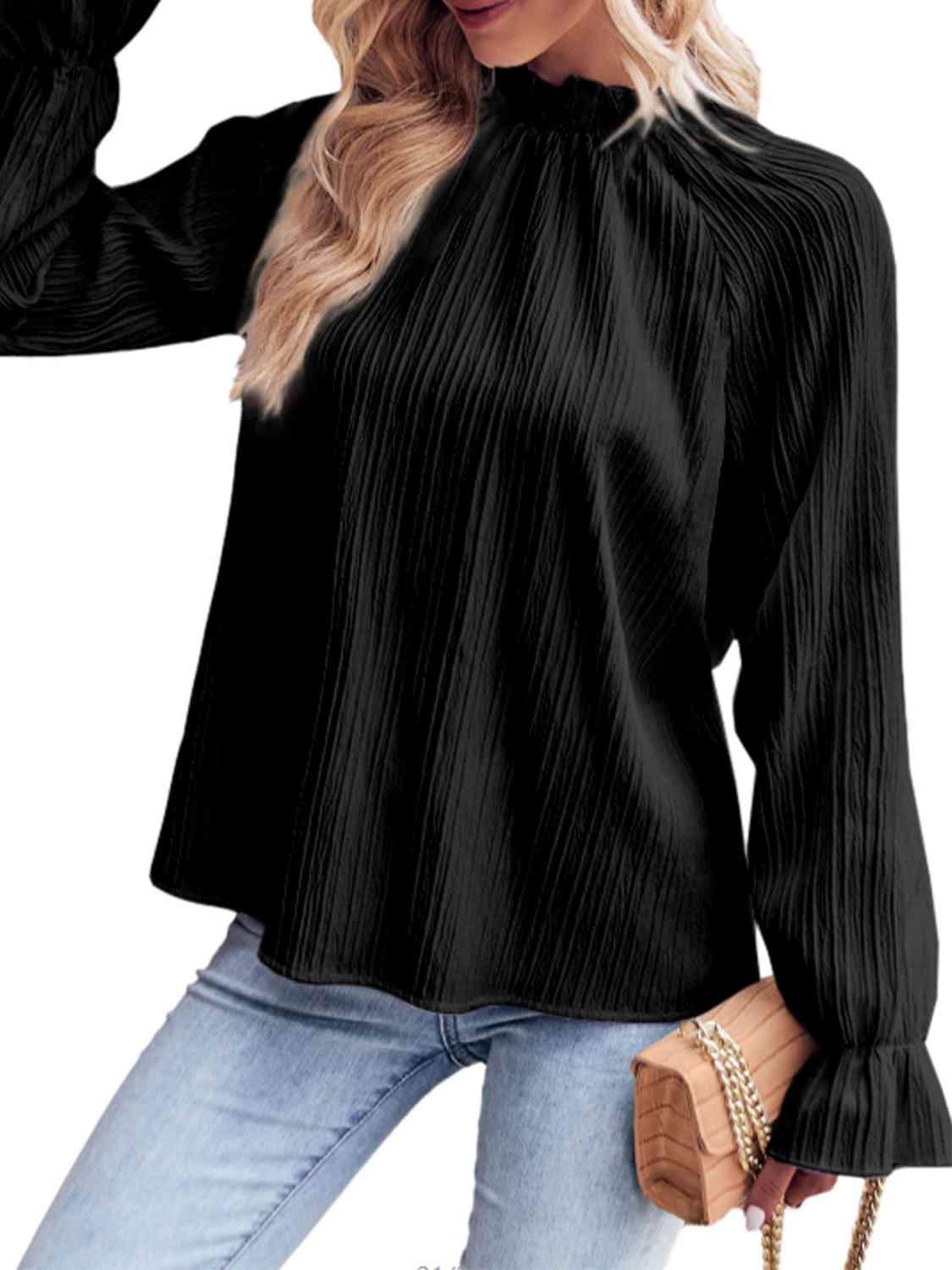 a woman wearing a black blouse and jeans