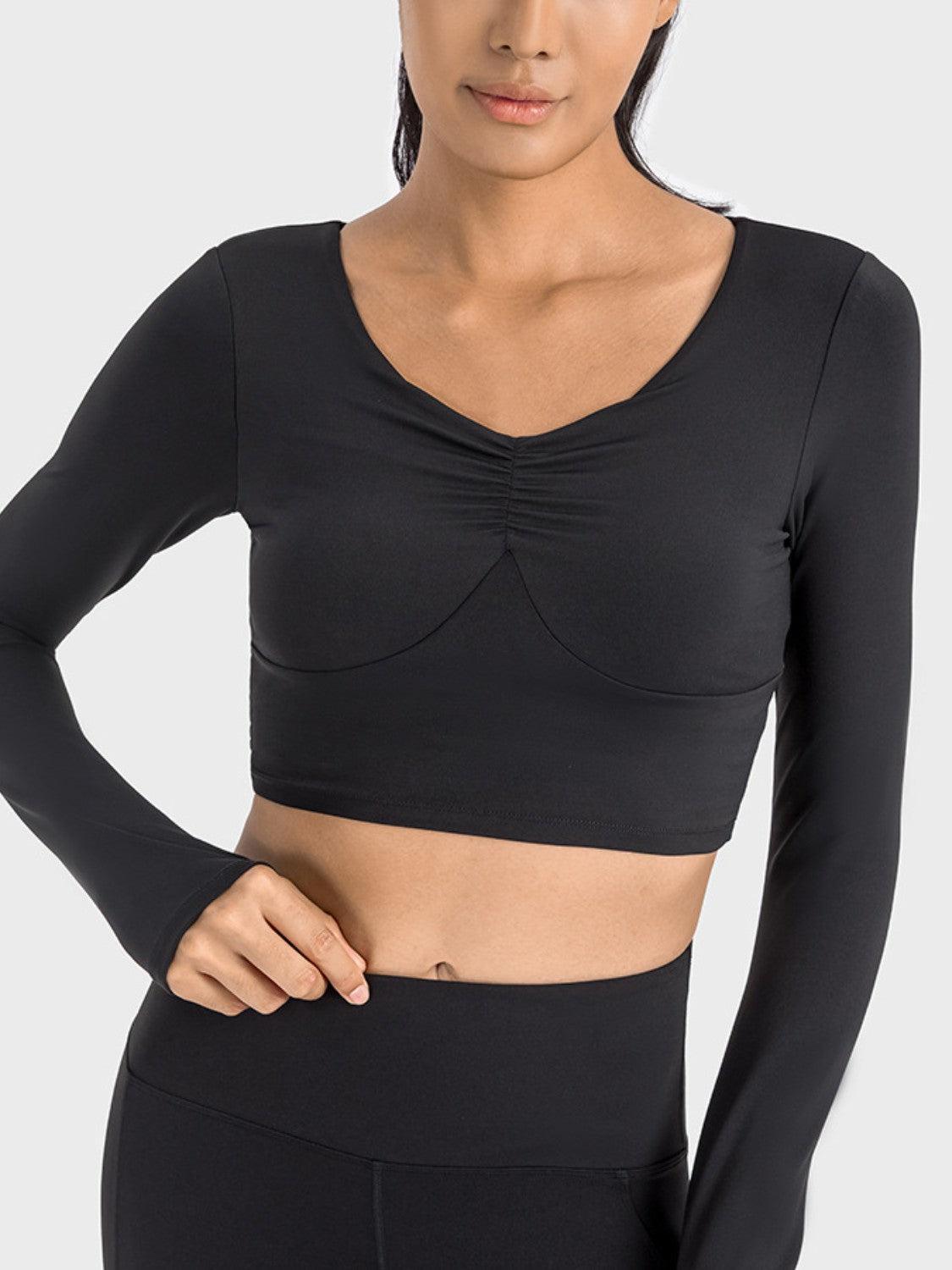 a woman wearing a black crop top and leggings