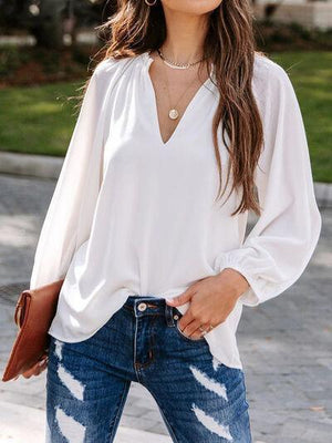 a woman wearing a white blouse and jeans