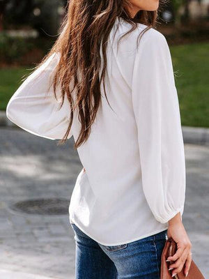 a woman wearing a white blouse and jeans