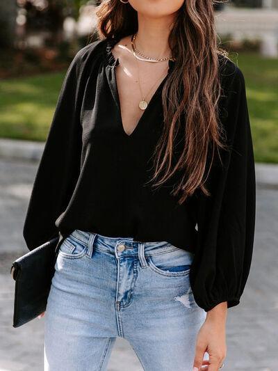 a woman wearing a black top and jeans