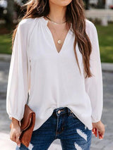 a woman wearing a white blouse and jeans