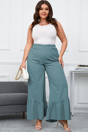 a woman in a white top and green pants