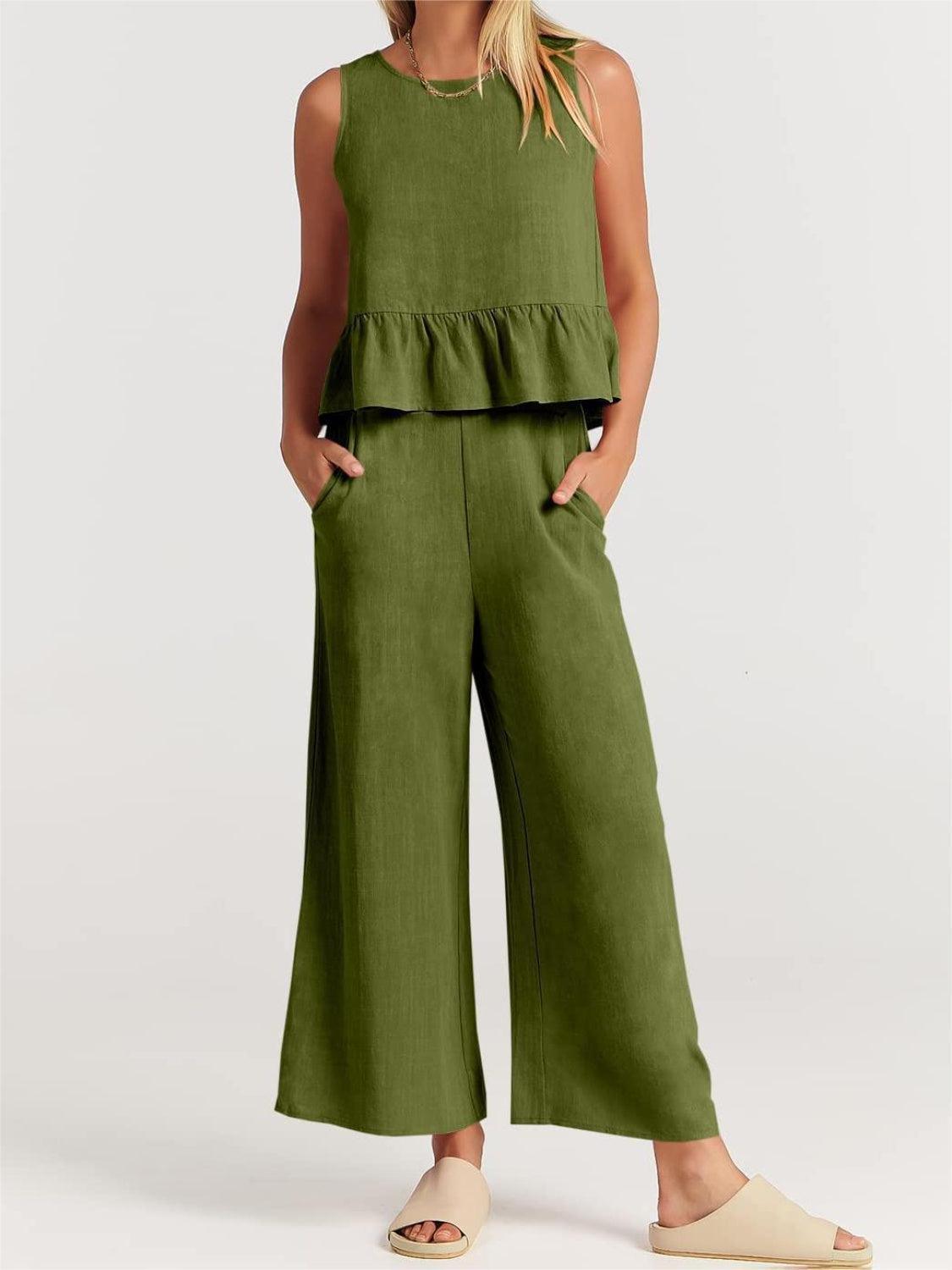 a woman wearing a green top and wide legged pants