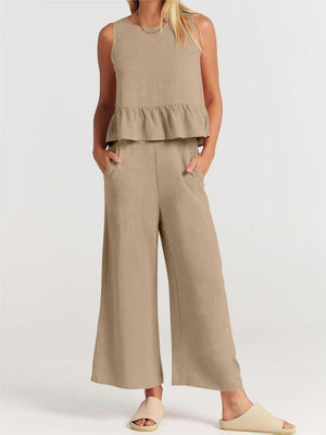 a woman wearing a tan top and wide legged pants