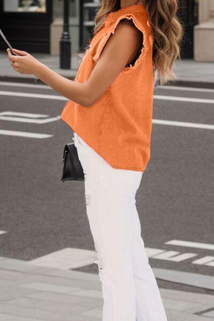 a woman in an orange top is looking at her cell phone