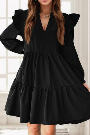 a woman wearing a black dress with long sleeves