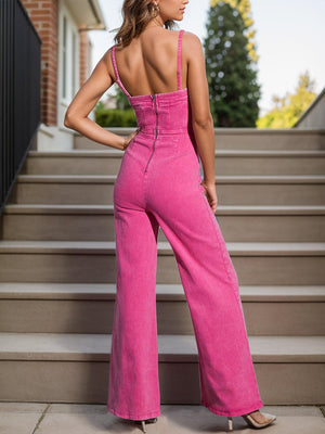 a woman in a pink jumpsuit standing on steps