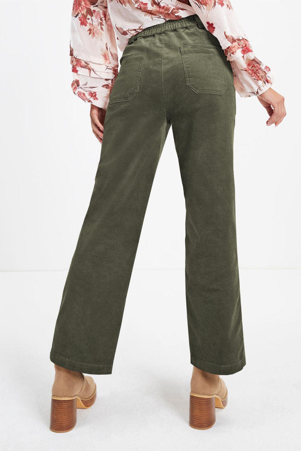 a woman in a floral shirt and green pants