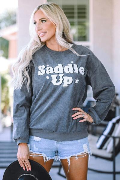 a woman wearing a sweatshirt that says saddle up