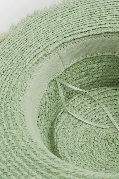 a close up of a green hat on a white surface