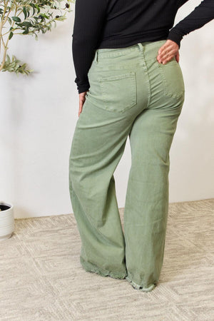a woman in a black top and green pants