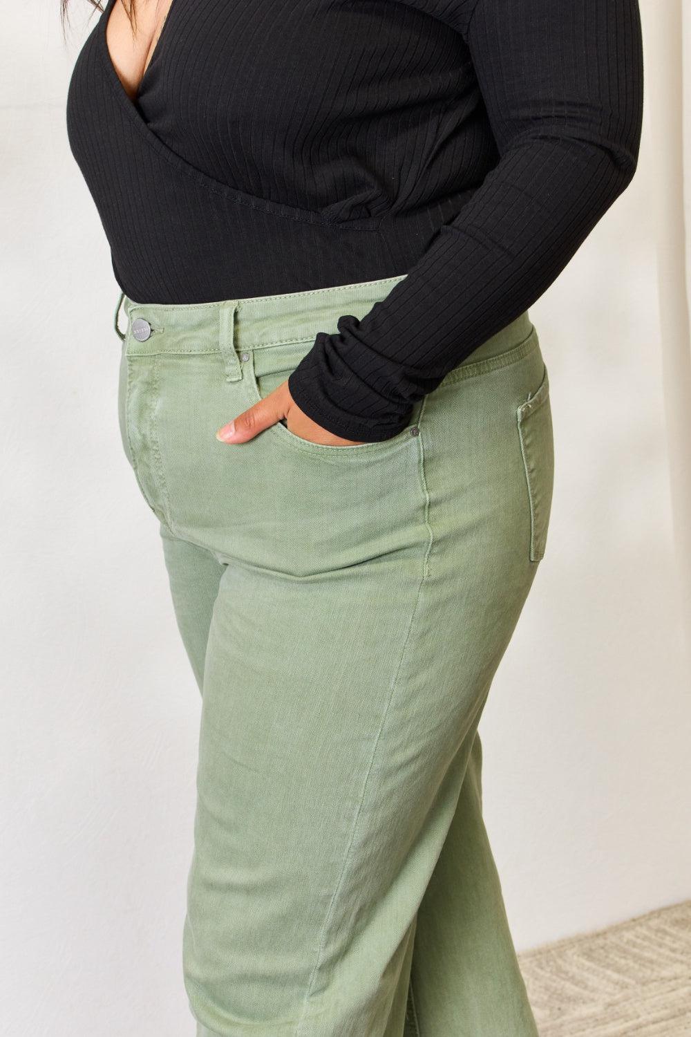 a woman in a black top and green pants