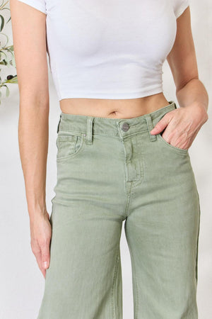 a woman wearing green pants and a white shirt