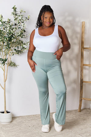 a woman in a white tank top and mint green pants