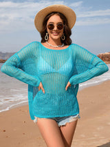 a woman standing on a beach wearing a hat and sunglasses