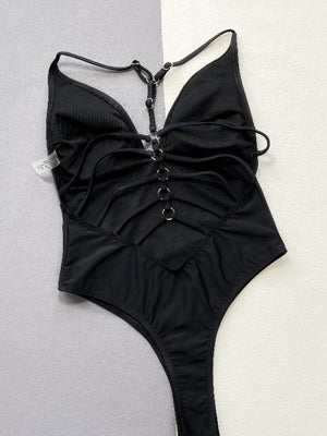 a woman wearing a black swimsuit with a halter