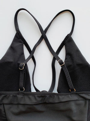 a pair of black straps are attached to a black bag