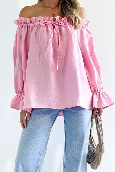 a woman wearing a pink top and jeans