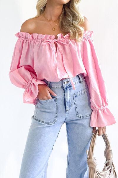 a woman wearing a pink top and jeans