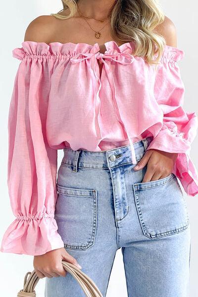 a woman wearing a pink top and jeans