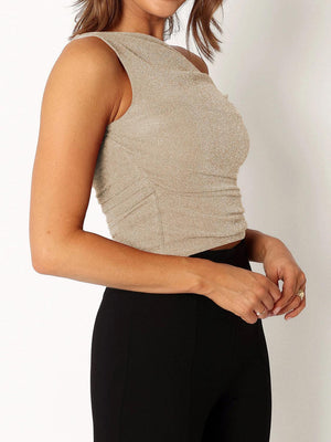 a woman wearing a tan top and black pants
