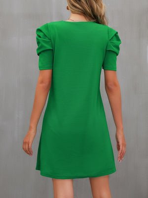 a woman in a green dress is looking back