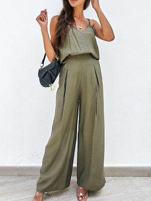 a woman in a green jumpsuit holding a black purse