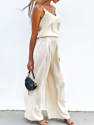 a woman in a white top and wide legged pants