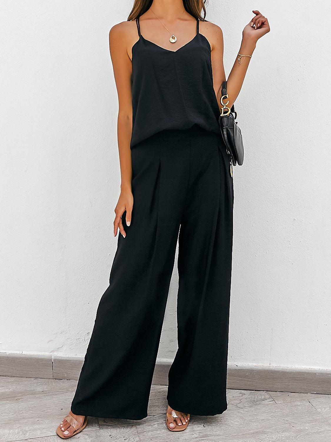a woman in a black tank top and wide legged black pants