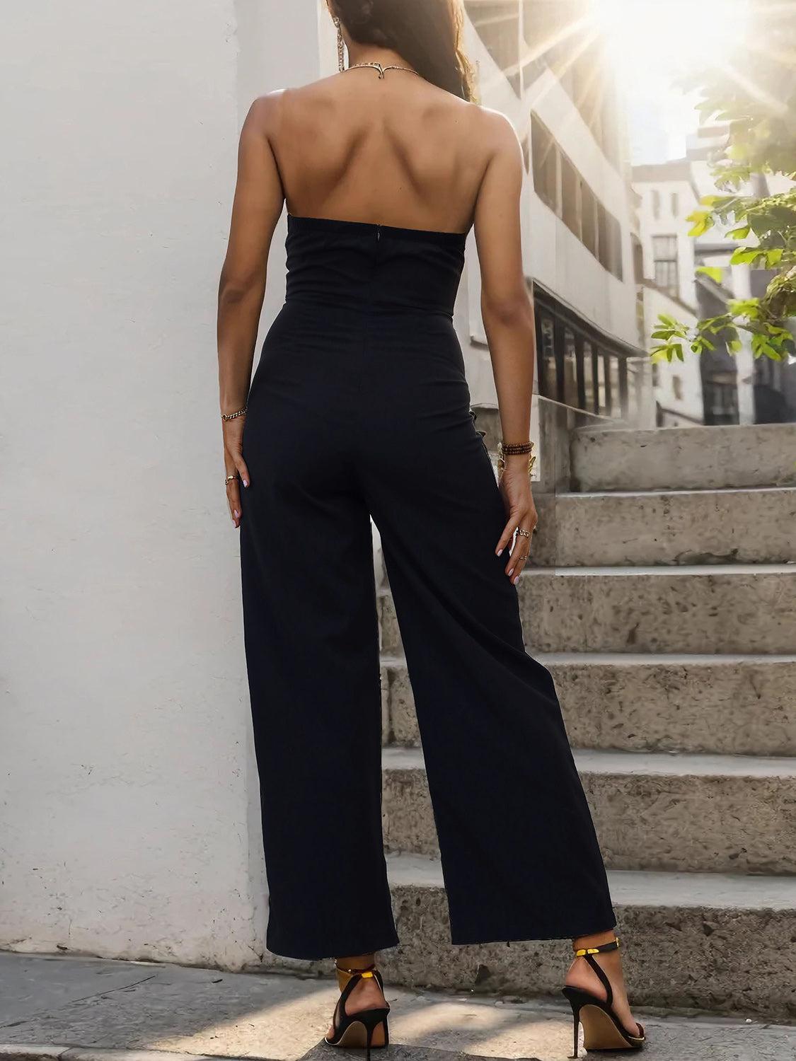 a woman in a black jumpsuit standing on steps