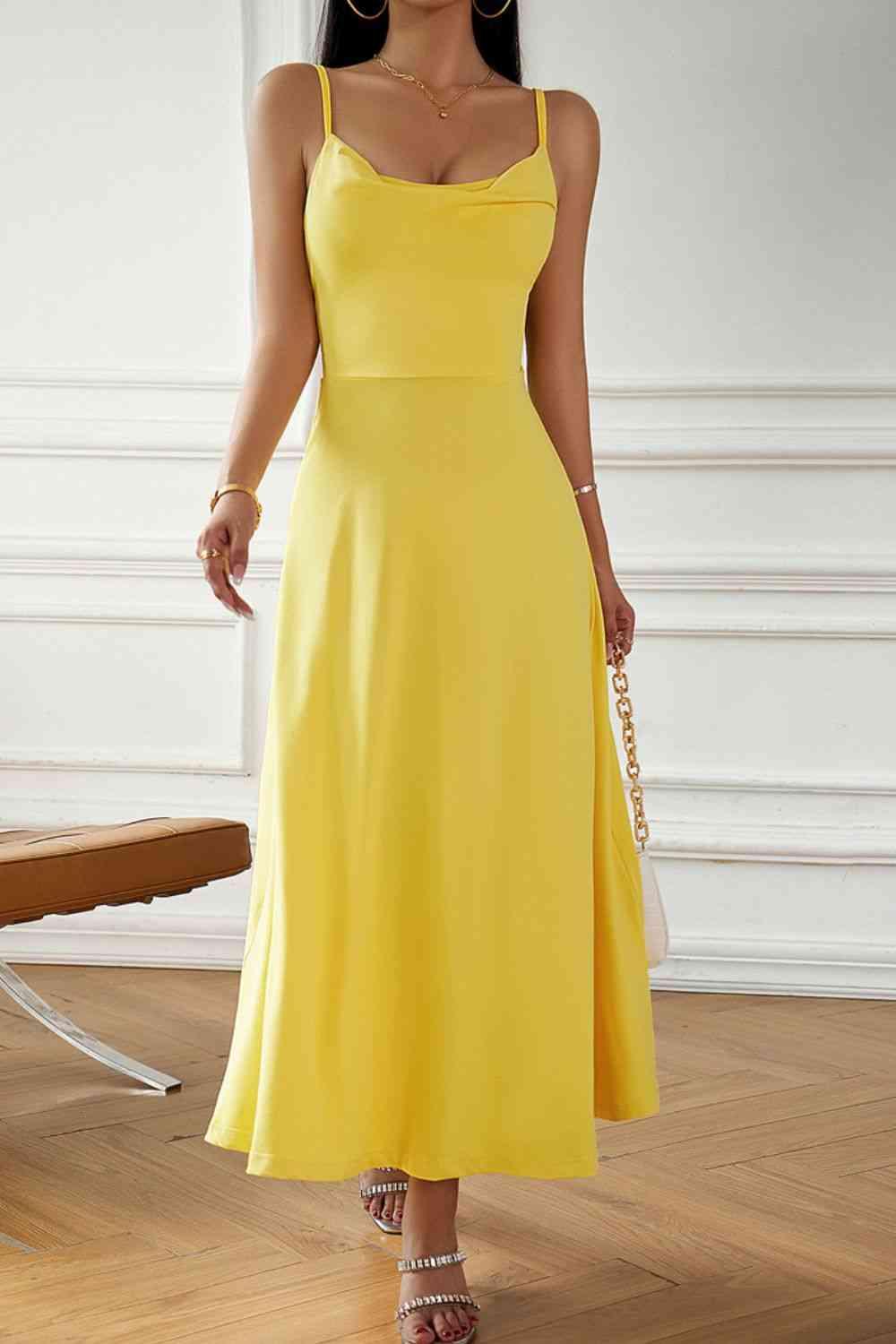 a woman in a yellow dress standing on a wooden floor